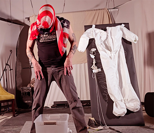 Performance artist Scotch Wichmann performing with American flag wrapped around his head to memorialize John M. White