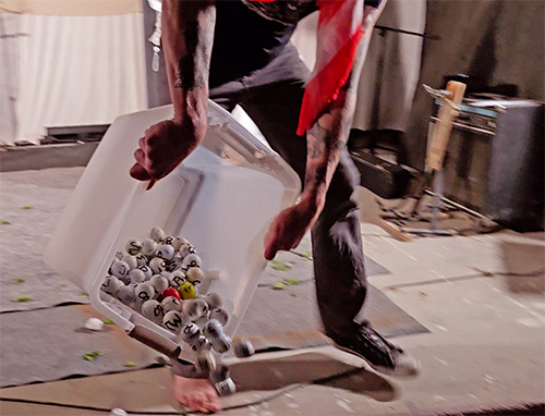 Performance artist Scotch Wichmann pouring 200 golf balls into audience